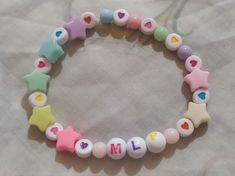 a close up of a bracelet on a bed with beads and letters that spell out love