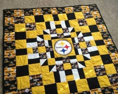 a quilt made to look like a pittsburgh football team logo on the side of a black and yellow checkered blanket