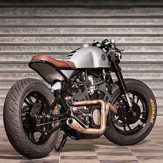 a silver and black motorcycle parked on top of a tiled floor