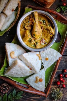 chicken curry in a bowl with pita bread and cranberries on the side