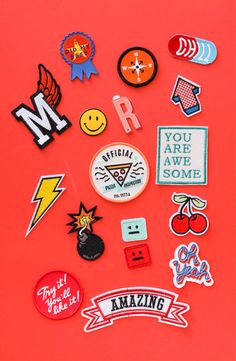 an assortment of stickers and magnets on a red surface