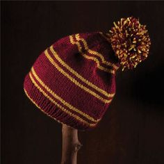 a red and yellow striped knitted hat with a pom - pom on top