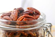 a glass jar filled with nuts sitting on top of a table