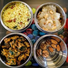 four metal bowls filled with different types of food and nuts on top of each other