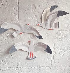 three paper plates shaped like birds on a wall