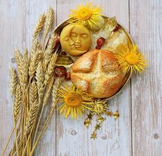 bread, sunflowers and other items are arranged on a white wooden table top