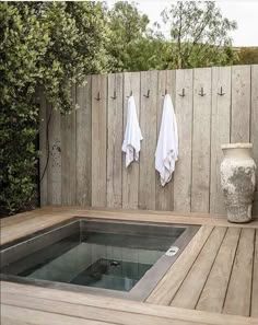 an outdoor hot tub with towels hanging on the wall