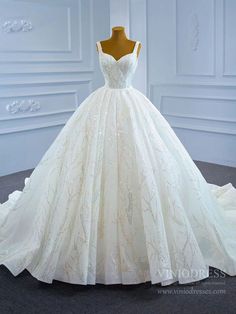 a wedding dress on display in a white room