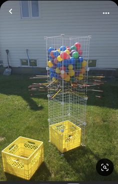 two yellow crates with balloons in them on the grass