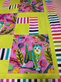 a cat is sitting on a patchwork quilt