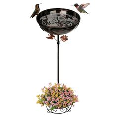 a bird bath with flowers and birds in it