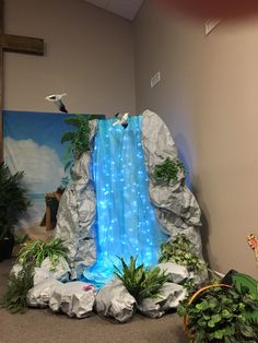 a room with a waterfall and plants on the floor