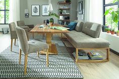 a living room with a couch, table and chairs next to a rug on the floor