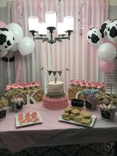 a table topped with lots of desserts and balloons