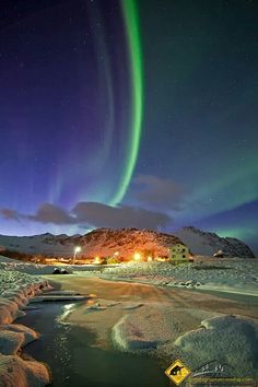 an aurora bore is seen above the snow covered ground in this photo, and it's lights shine brightly