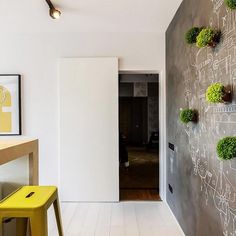 a white room with chalk writing on the wall and yellow stools next to it