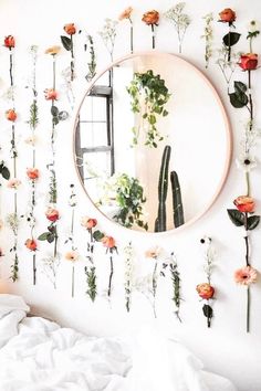 a bedroom with flowers on the wall and a round mirror hanging from it's side