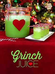 green juice in a jar with candy canes on the table next to christmas tree