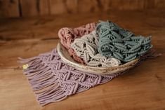 a bowl filled with yarn sitting on top of a wooden table