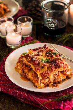 a white plate topped with lasagna covered in sauce