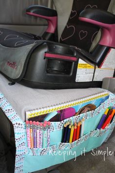 an organized car seat back organizer with pens, pencils and crayons in it