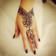 a woman's hand with henna tattoos on it