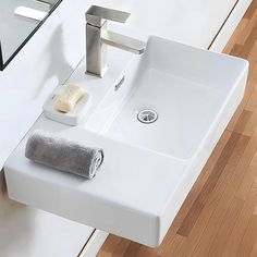 a white bathroom sink sitting on top of a wooden floor