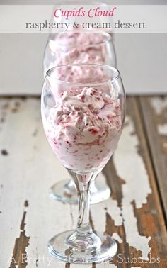 raspberry and cream dessert in a wine glass on a wooden table with text overlay