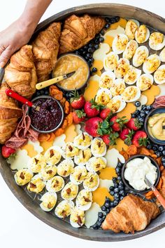 a platter filled with croissants, fruit and other foods