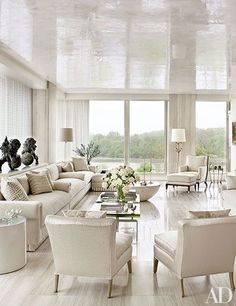 a living room filled with lots of white furniture