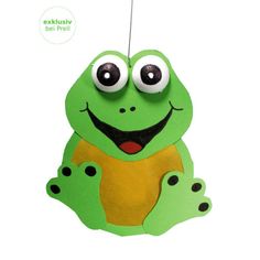 a green frog with big eyes hanging from a string