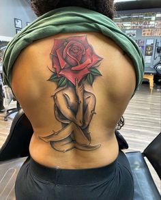 a woman with a rose tattoo on her back