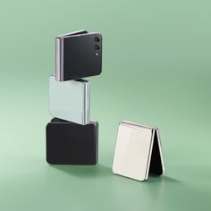 two cell phones stacked on top of each other in different colors and shapes, with one being opened to reveal the camera