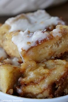 a close up of a plate of food with doughnuts on top and icing