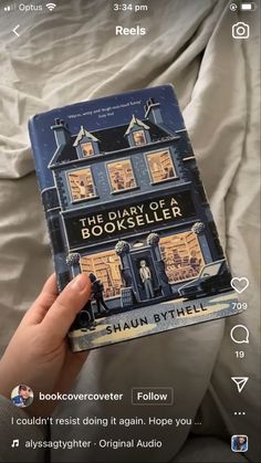 someone holding up a book about the story of booksellerer in front of a bed