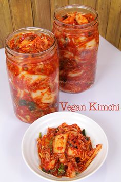 two jars filled with food sitting on top of a white table next to each other