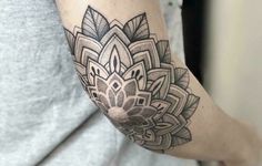 a woman's arm with a tattoo on it and an intricate flower in the center