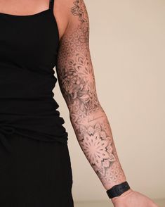 a woman's arm with tattoos on it and a wristband in the shape of a flower