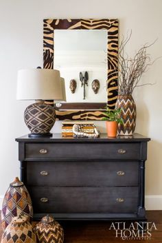 a dresser with two vases and a mirror on top