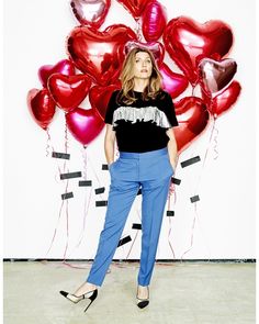 a woman standing in front of balloons with her hands on her hips and looking up