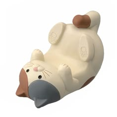 a white and brown toy animal laying on its back