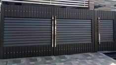 a black gate with metal bars on the top and bottom, in front of a house