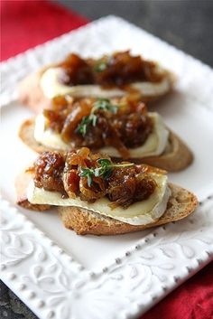 two pieces of bread with meat and cheese on them are sitting on a white plate