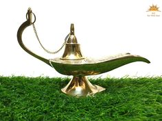 a brass oil lamp sitting on top of green grass