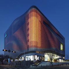 the building is lit up at night with bright lights on it's sides and windows