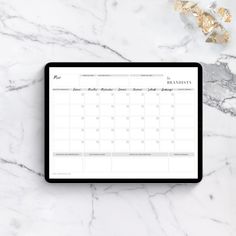 a tablet with a calendar on it sitting next to some gold foil and confetti