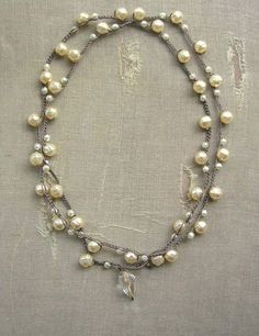 a necklace with pearls and a cross on it