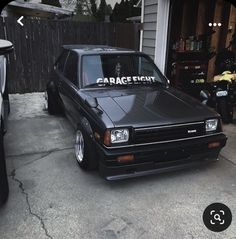 a black car parked in front of a garage