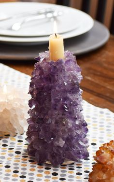 a candle that is sitting on top of a table next to some rocks and crackers