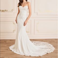 a woman in a white wedding dress standing on a wooden floor next to a wall